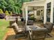 Relax on the stone patio with an outdoor fireplace, a dining area, and views of a serene pool and landscaped yard at 970 Tarpley Nw Rd, Kennesaw, GA 30152