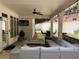 Covered patio with stone flooring, a large outdoor seating area, ceiling fan and a mounted TV at 970 Tarpley Nw Rd, Kennesaw, GA 30152