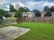 Large, fully fenced backyard with lush green grass and mature trees at 2424 Saint Andrews Rdg, College Park, GA 30337
