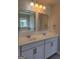 Bright bathroom featuring double sinks, white cabinets and countertops, with well-lit mirrors at 2424 Saint Andrews Rdg, College Park, GA 30337