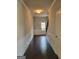 Welcoming hallway with hardwood floors, wainscotting and neutral walls that leads to a light-filled entryway at 2424 Saint Andrews Rdg, College Park, GA 30337