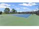 Well-maintained green and blue community tennis courts on a sunny day with light clouds in the sky at 3560 Bexton Dr, Duluth, GA 30097