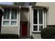 Attractive exterior with large windows and red door, plus an address plaque for 