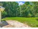 Large backyard features a patio and green space, with mature trees at 230 Belmont Trl, Covington, GA 30016