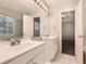 Bright bathroom featuring a double vanity, large mirror, and white tiled floors at 230 Belmont Trl, Covington, GA 30016