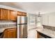 A well-lit kitchen featuring stainless steel appliances, granite countertops, and wood cabinets at 230 Belmont Trl, Covington, GA 30016