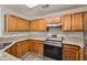 Well-equipped kitchen featuring granite countertops, wooden cabinets, and stainless steel appliances at 230 Belmont Trl, Covington, GA 30016