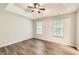 Spacious main bedroom with tray ceiling, ceiling fan, wood-look floors and natural light at 230 Belmont Trl, Covington, GA 30016