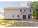 Back of the house with light gray siding with a walk-out patio, surrounded by mature trees and a lawn at 2346 Hampton Park Dr, Buford, GA 30519