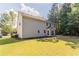 View of the back of the house, showing the exterior siding and large yard with mature trees in the background at 2346 Hampton Park Dr, Buford, GA 30519