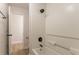 This bathroom features a white tub and shower with dark fixtures, with a view of the light-colored floor just outside the door at 2346 Hampton Park Dr, Buford, GA 30519