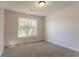 Bright bedroom featuring a large window, neutral walls, and plush carpeting at 2346 Hampton Park Dr, Buford, GA 30519