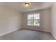 Cozy bedroom with a large window, neutral-colored walls, and carpet flooring at 2346 Hampton Park Dr, Buford, GA 30519