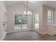 Dining area with vaulted ceiling, chandelier, and large windows bringing in natural light at 2346 Hampton Park Dr, Buford, GA 30519