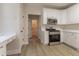 Modern kitchen with stainless steel appliances, white cabinets, and light-colored flooring at 2346 Hampton Park Dr, Buford, GA 30519