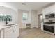 Spacious kitchen featuring white cabinets, stainless steel appliances, and large windows at 2346 Hampton Park Dr, Buford, GA 30519