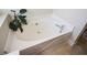 Corner soaking tub with a plant nearby at 3332 Chastain Landings Ct, Marietta, GA 30066