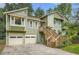 Charming two-story home with green siding, wooden stairs, and a two-car garage at 5093 Ravenwood Dr, Marietta, GA 30066
