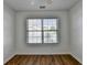 Bright bedroom featuring hardwood floors and a window with neighborhood views at 609 Bedford Court, Woodstock, GA 30188