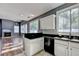 Open kitchen with white cabinets and black countertops leading into a living area at 609 Bedford Court, Woodstock, GA 30188