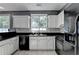 Charming kitchen featuring white cabinets, black countertops and appliances, and subway tile backsplash at 609 Bedford Court, Woodstock, GA 30188