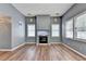 Bright living room featuring a fireplace, hardwood floors, and ample natural light from large windows at 609 Bedford Court, Woodstock, GA 30188
