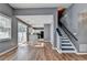 View of the living room showcasing hardwood floors, a staircase, and an open connection to the kitchen at 609 Bedford Court, Woodstock, GA 30188