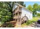 Two-story home with double balconies, wooden steps, and charming curb appeal surrounded by lush trees at 1112 Smith St, Atlanta, GA 30310