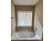 A clean, white bathtub is situated below a window, providing natural light in the bathroom at 378 Durmire Dr, Jonesboro, GA 30236