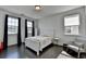 Bright bedroom with dark hardwood floors, a white bed frame, and large windows at 4583 Roskin St, Duluth, GA 30097