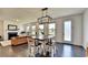 Bright dining area with modern chandelier, dark wood floors, and an open view to the living room with fireplace at 4583 Roskin St, Duluth, GA 30097