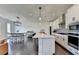 Open-concept kitchen with stainless steel appliances, white cabinetry, island seating, and an adjacent dining area at 4583 Roskin St, Duluth, GA 30097