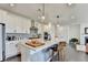 Modern kitchen features white cabinetry, stainless steel appliances, a center island with bar seating, and beautiful pendant lighting at 4583 Roskin St, Duluth, GA 30097