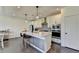 The modern kitchen features stainless steel appliances, white cabinetry, an island with bar seating, and lovely pendant lights at 4583 Roskin St, Duluth, GA 30097