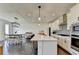 Open concept kitchen with an island, white cabinets, stainless steel appliances, and an adjacent dining area with modern lighting at 4583 Roskin St, Duluth, GA 30097
