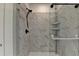 This walk-in shower features stunning marble-look tile, modern fixtures, and a shower shelf for an added touch of luxury at 4583 Roskin St, Duluth, GA 30097