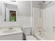 Bathroom features a white vanity, toilet, tub, shower, and paneled walls at 658 Slew Ave, Lawrenceville, GA 30043