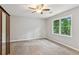 Spacious bedroom with new carpet, closet, a ceiling fan, and a window with nature views at 658 Slew Ave, Lawrenceville, GA 30043