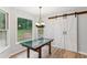 Dining area with wood-look floors, windows with nature views, and a sliding barn door at 658 Slew Ave, Lawrenceville, GA 30043