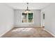 Dining room featuring neutral paint, chandelier, and a window at 658 Slew Ave, Lawrenceville, GA 30043