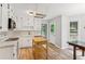 Bright kitchen with white cabinets, stainless appliances, a mobile island, and new wood-look floors at 658 Slew Ave, Lawrenceville, GA 30043