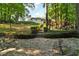 Secluded backyard with a stone patio and a lush, landscaped yard with stairs leading to the home at 1590 Sunnybrook Farm Rd, Atlanta, GA 30350