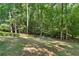 A gently sloped backyard is surrounded by lush trees and foliage at 1590 Sunnybrook Farm Rd, Atlanta, GA 30350