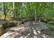 A stone patio with lush trees provides a tranquil spot for relaxation at 1590 Sunnybrook Farm Rd, Atlanta, GA 30350