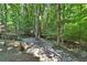 Backyard with a stone patio, mature trees, and lush landscaping at 1590 Sunnybrook Farm Rd, Atlanta, GA 30350