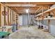 Unfinished basement featuring exposed wood beams, cement floor, open space, and installed storage shelves at 1590 Sunnybrook Farm Rd, Atlanta, GA 30350