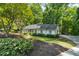 Well-maintained exterior with a lush green lawn, meticulous landscaping, and a charming light-colored facade at 1590 Sunnybrook Farm Rd, Atlanta, GA 30350
