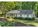Well-maintained exterior with a lush green lawn, meticulous landscaping, and a charming light-colored facade at 1590 Sunnybrook Farm Rd, Atlanta, GA 30350