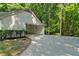 Attached garage with a long driveway and surrounding lush trees at 1590 Sunnybrook Farm Rd, Atlanta, GA 30350