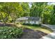 Attractive single-story home with mature landscaping, driveway, and lush green surroundings at 1590 Sunnybrook Farm Rd, Atlanta, GA 30350